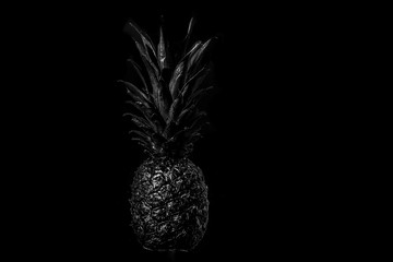 Obraz premium Black pineapple on black background studio photography of delicious foodstuffs