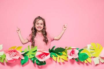 Obraz na płótnie Canvas Portrait of a little girl on a summer pink background