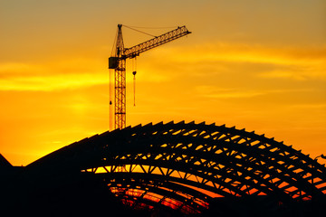Industrial machinery, construction crane. Cranes and frame sports arena under construction, city...