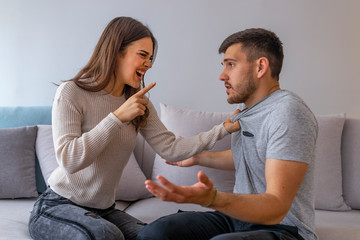 Young couple in conflict, man and woman fight. Furious couple arguing while having problems in their relationship.  Young couple arguing while having problems in their relationship.