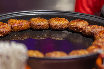 Process of cooking hot meatballs at street food festival. Outdoor cooking service gastronomy and takeaway food concept