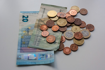 Dirty money euro banknotes and coins on white table. Dark business concept