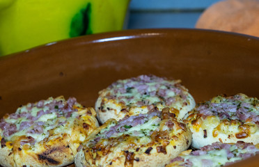 SMALL PIZZAS IN A ROLLED PLATE IN A KITCHEN TABLE