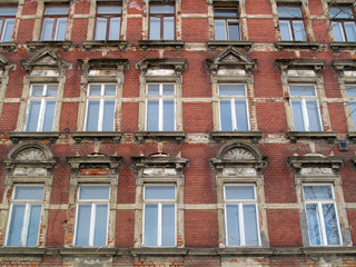 Fototapeta na wymiar Old house facade non renovated with red bricks in germany