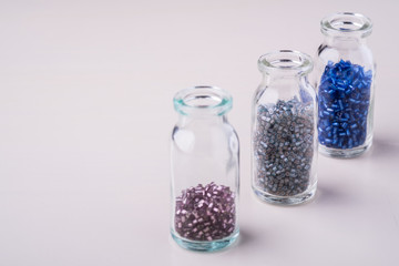 Varied colors beads in transparent bottles white background