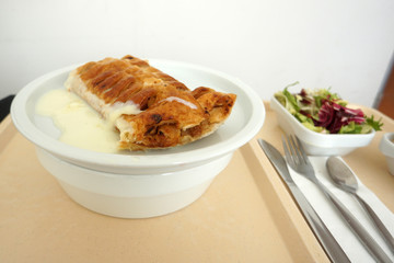 Delicious apple strudel with custard and fruit salad in a canteen in Germany
