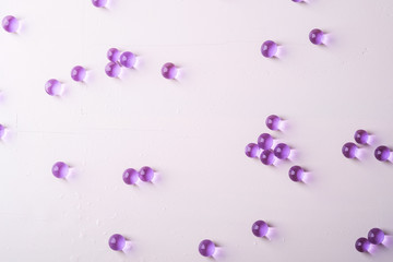 Purple scattered marbles on white background top view