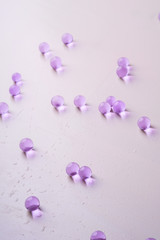 Purple scattered marbles on white background close up