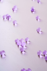 Fototapeta premium Purple scattered marbles on white background close up