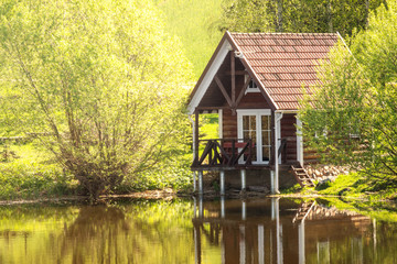 Small wooden house near the pond - Powered by Adobe