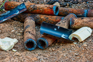 Bunch of rusty pipes is lying on the ground