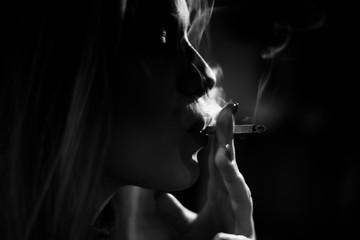 Woman smoking a cigarette, black and white,artistic, some photo grain