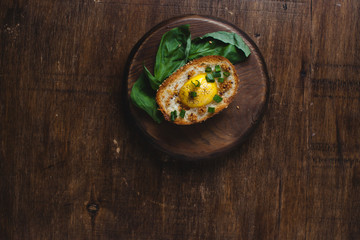 Sandwiches with eggs, basil, and chopped fresh green onions on the wooden background, top view