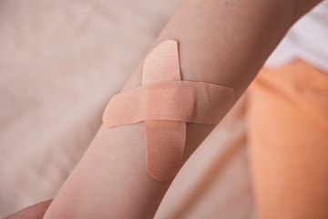 The hands of a boy with a patch of adhesive attached to his hands.
