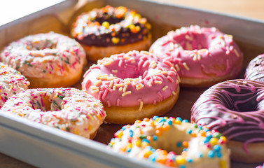 Assorted sweet donuts in a paper box.