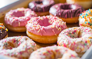 Assorted sweet donuts in a paper box.