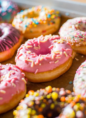 Assorted sweet donuts in a paper box.