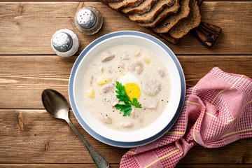 Traditional polish soup Zurek on wooden table. Top view.