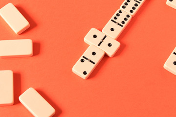 Playing dominoes on a red background. Domino effect.