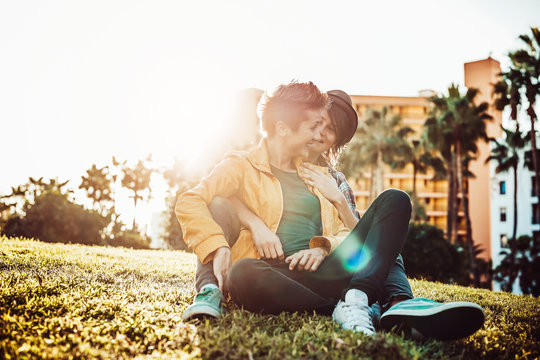 Happy gay couple embracing and laughing together in park outdoor - Young lesbian women having a tender moment at sunset outside  - People, Lgbt, bisexuality, relationship lifestyle concept