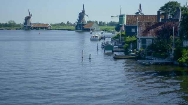 Mills of Koog aan de Zaan in Netherlands in the background while the river is in the foreground.