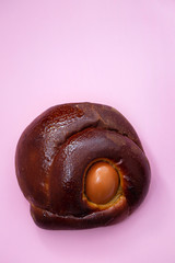 typical Portuguese Easter cake Folar with egg on pink background