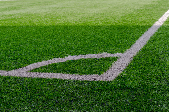 White marking corner on a bright green football field.