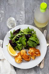 fried squid with salad and lemon on white plate