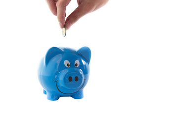 saving money plan concept, hand put the golden coin in to blue piggy bank isolate on white background.