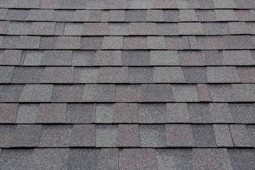 dark new roof shingle background and texture. asphalt tiles of house roof.