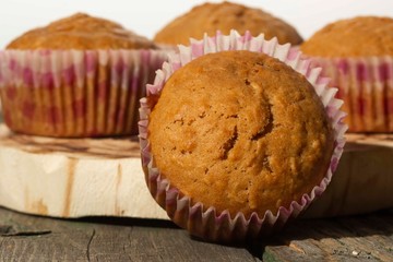 homemade muffins with coconut chips on a wooden stand