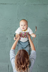 Fototapeta premium Young mother holds her confused little baby