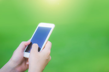 hipster woman using mobile phone touching screen at outdoor in green park background, hands typing smart phone texting messaging lifestyle working app device technology internet social online concept.
