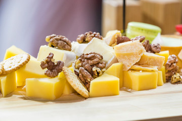 Cheese plate close-up with several varieties of fruit and honey cheese.