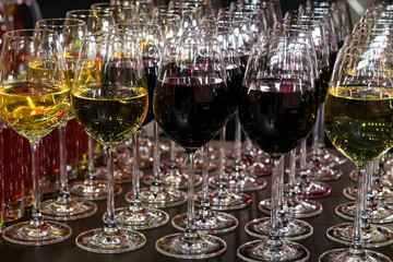 Rows of glasses full of wine at a romantic banquet at a nightclub close-up shot.