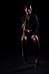 Fototapeta na wymiar The beauty woman holding Flute in hand and playing music,sexy model posing with woodwind instrument,classic and art tone