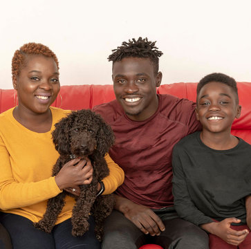 Hampshire, UK. circa 2019. Family portrait with a black Poddle pet dog