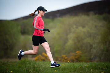 Fit senior woman in 50s exercising and keeping fit by running in a park