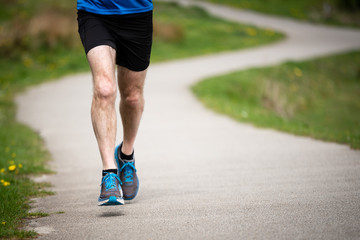 Senior man in 50s exercising and keeping fit by running in a park