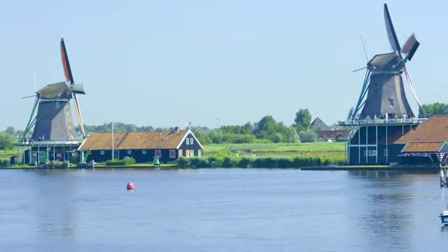 Mills of Koog aan de Zaan in Netherlands in the background whilr the river is in the foreground.