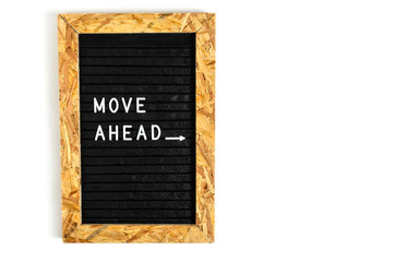 Letter board with motivating inscription move ahead in white letters on black.