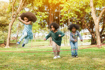 Children jumping over the rope in the park