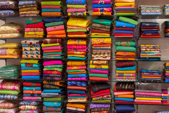 Beautiful Indian coloured cloth fabric folded on shelves for sale at Global Village creating a nice background