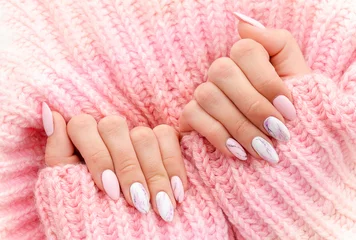 Foto op Plexiglas Vrouwelijke handen manicure close-up uitzicht op roze gebreide trui achtergrond. Nagellak effecten. Manicure salon banner concept © woodpencil