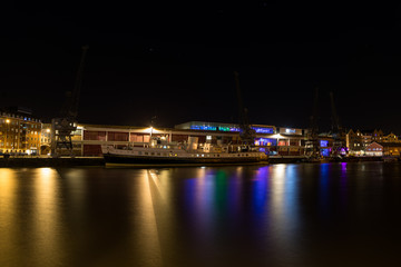 Fototapeta na wymiar Boat in Bristol Floating Harbour at night with the M Shed behind.