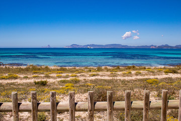Typical balearic natural reserve vooden fence, and blue mediterranean sea on the background; Formentera Island, Spain