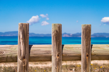 Typical balearic natural reserve vooden fence, and blue mediterranean sea on the background; Formentera Island, Spain