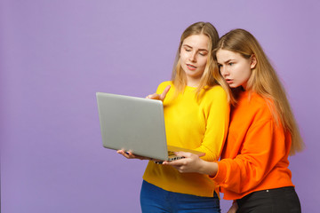 Two young blonde twins sisters girls in vivid colorful clothes h