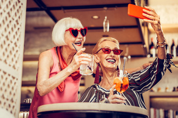 Fashionable grey-haired senior ladies wearing funky sunglasses