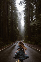 woman in blue dress on road in forest redwoods - 265498745